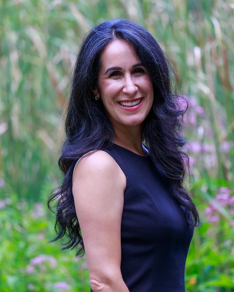 Noa Ferguson smiling, standing outdoors among tall summer grasses